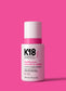K18 HeatBounce hair product bottle on a pink background