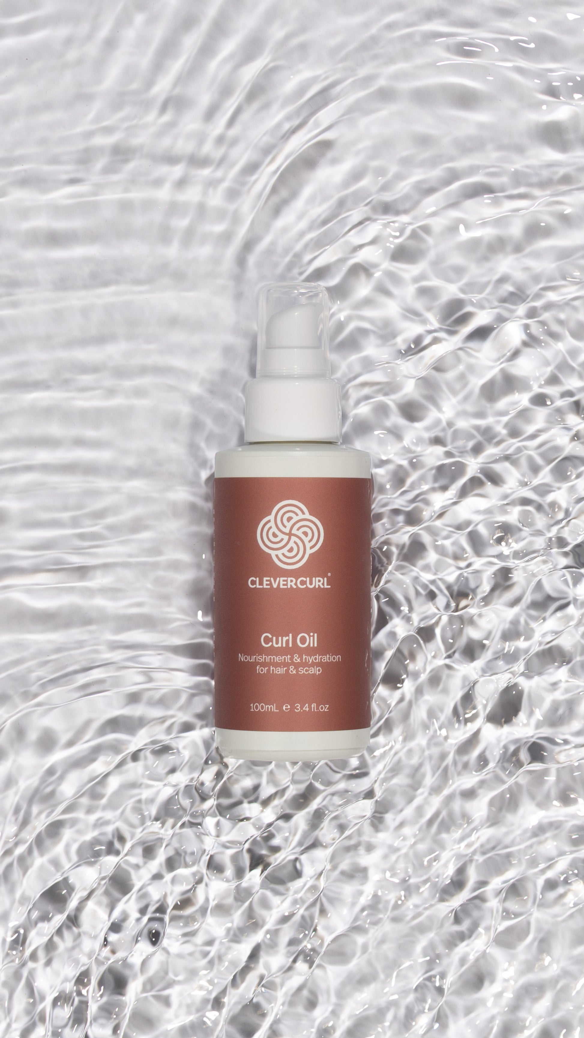 Curl oil bottle with a textured gray background