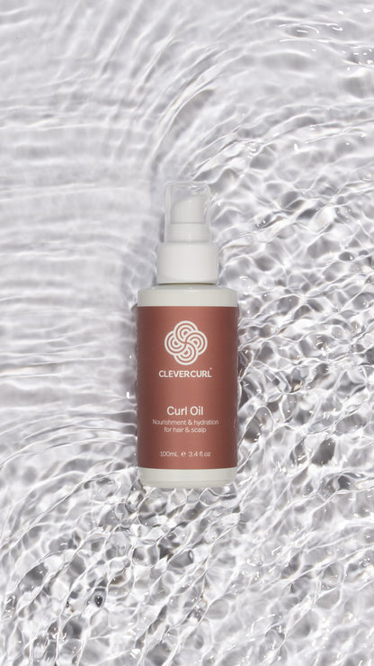 Curl oil bottle with a textured gray background